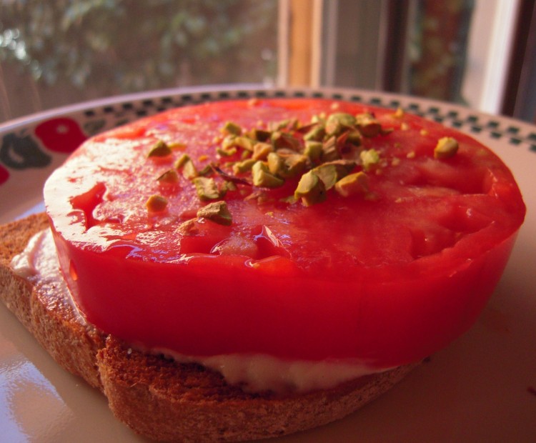 Heirloom tomato sandwich open face with crushed pistachios on top