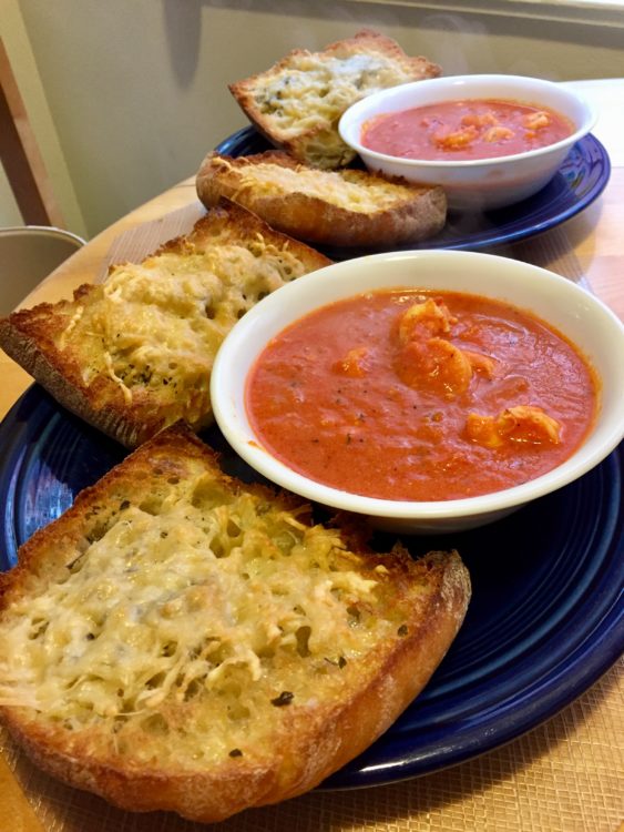 Bowls of arrabiata sauce with large slabs of garlic-cheese bread on the side